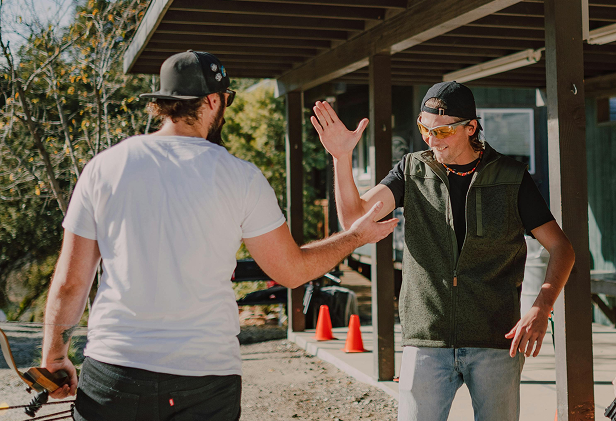 Two men high-fiving outdoors