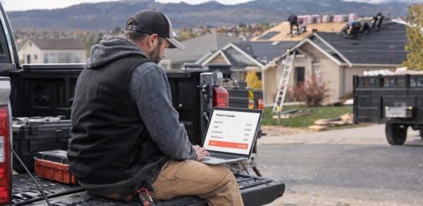 Contractor reviewing SEO cost report on laptop at job site